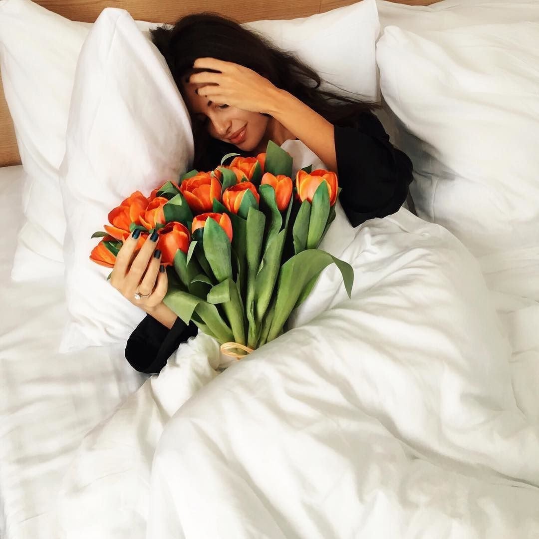 Девушка с цветами на кровати