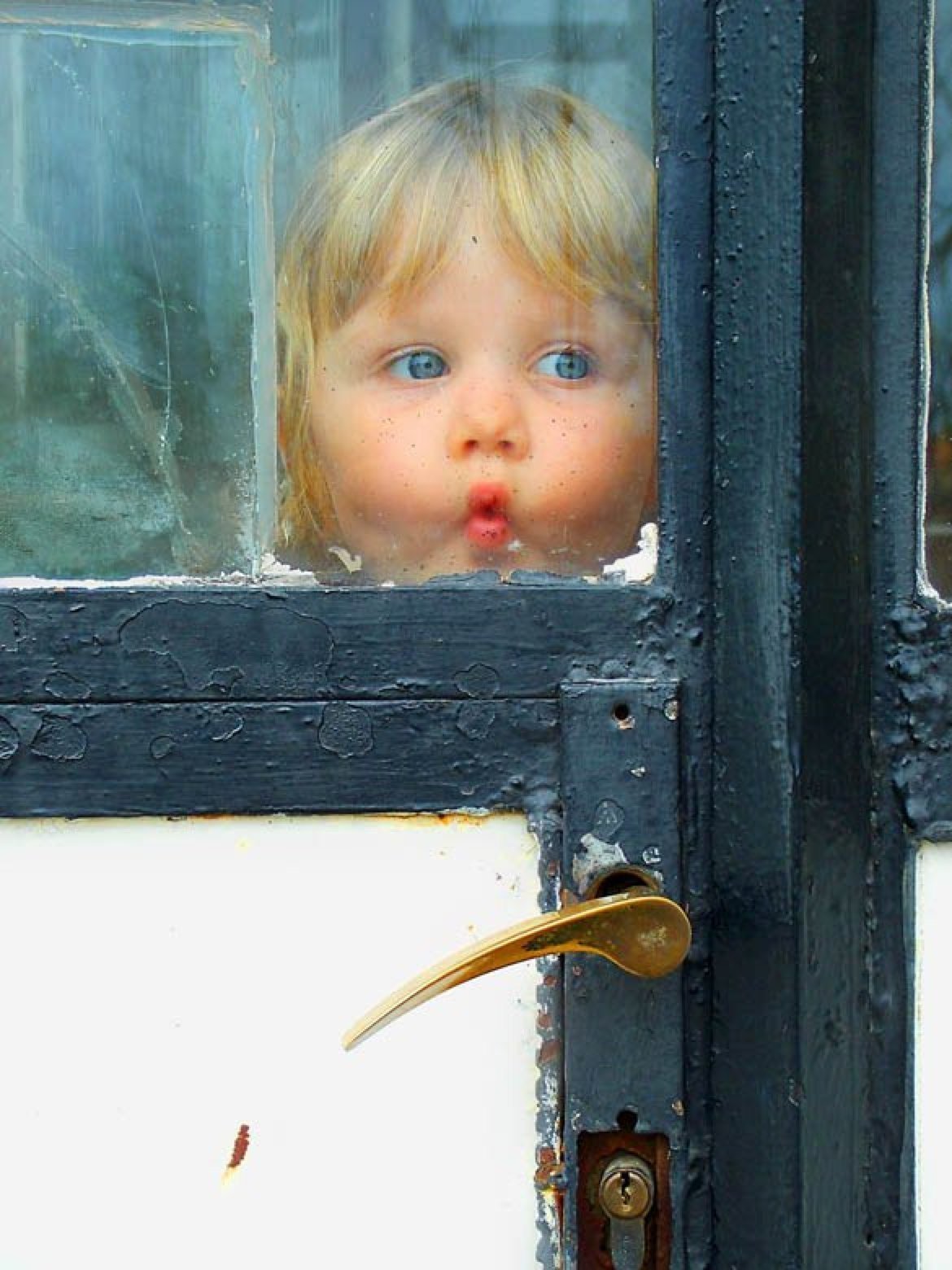 Малыш стучит. Ребенок у окна. Заглядывает в окно. Мальчик заглядывает в окно.
