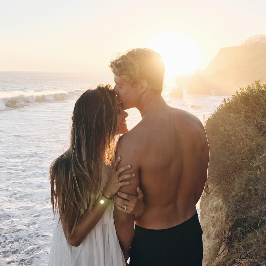 Парень обнимает девушку на море