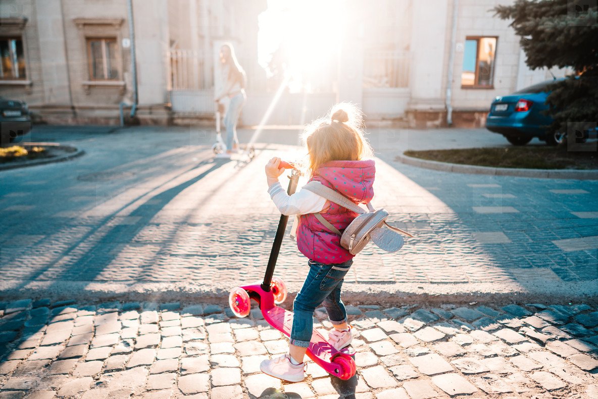 Девочка на самокате спиной