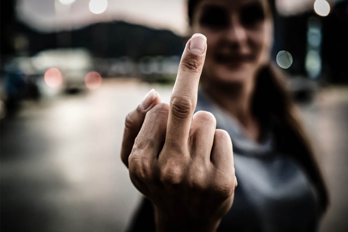 Показывает средний палец