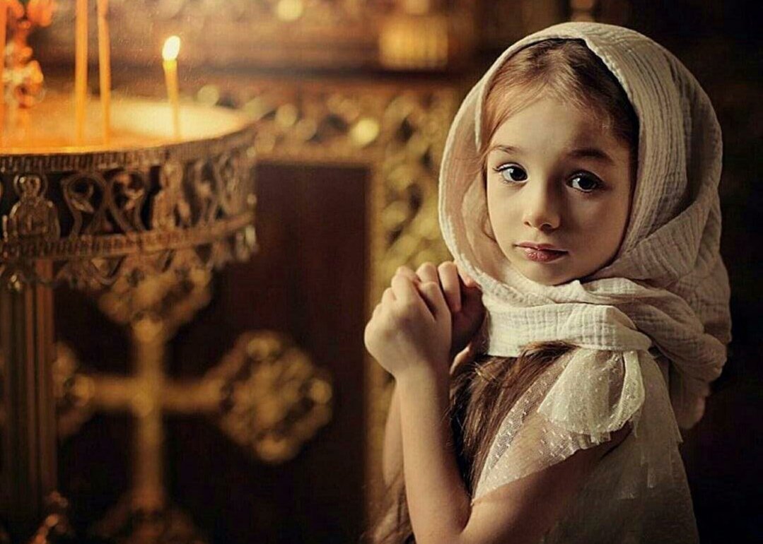 Девочка молится в храме