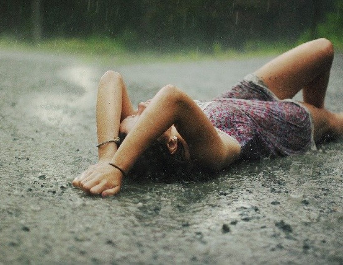 Девушка лежит под дождем