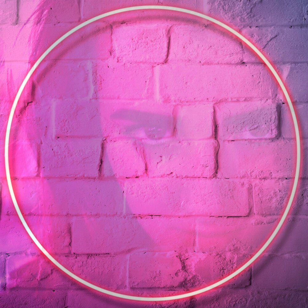 Неоновый круг на кирпичной стене
