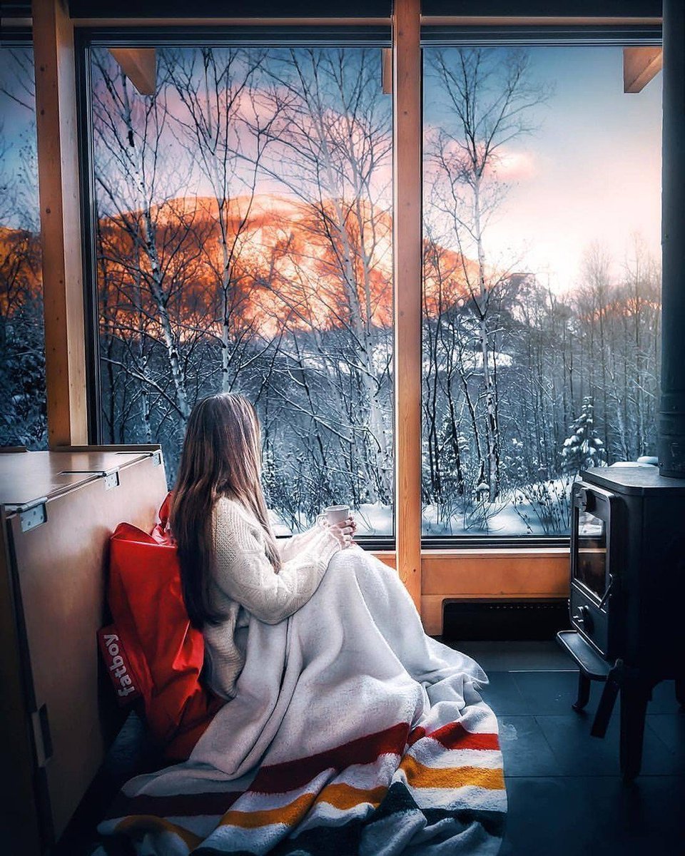 Девушка с чашкой кофе у окна