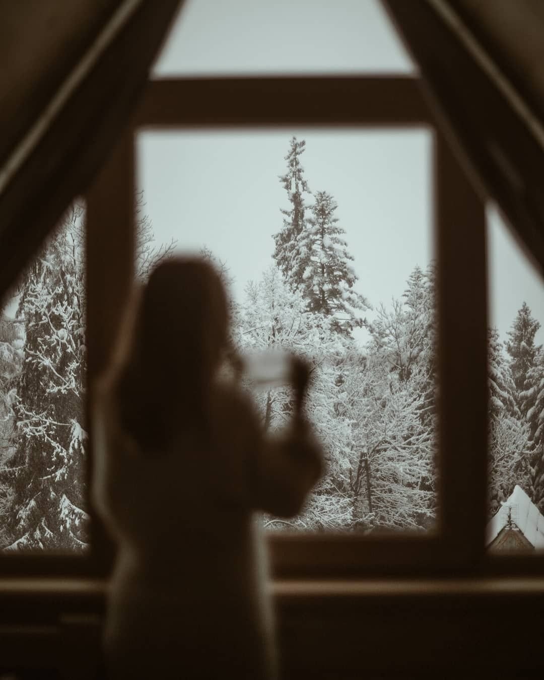 Девушка смотрит в окно на звездное небо