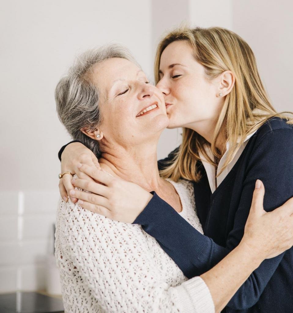 Взрослая дочь обнимает маму