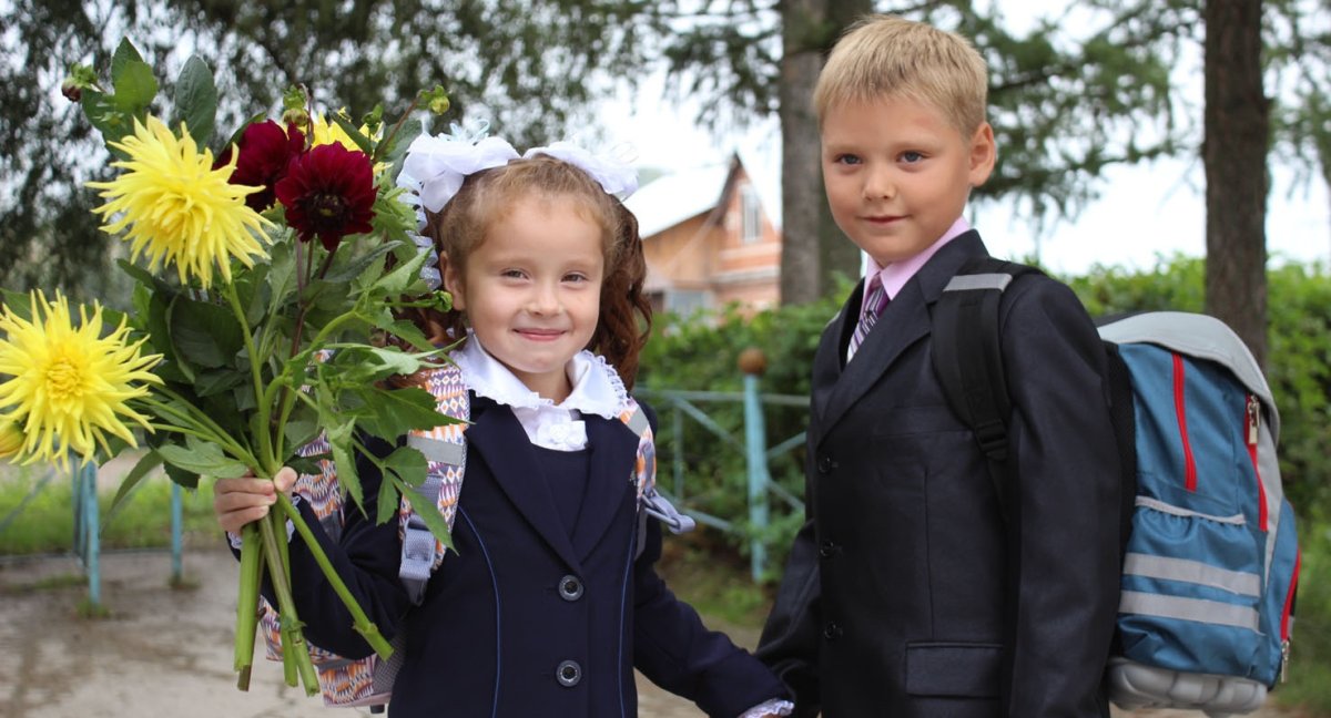 Родители ведут в школу первоклассника