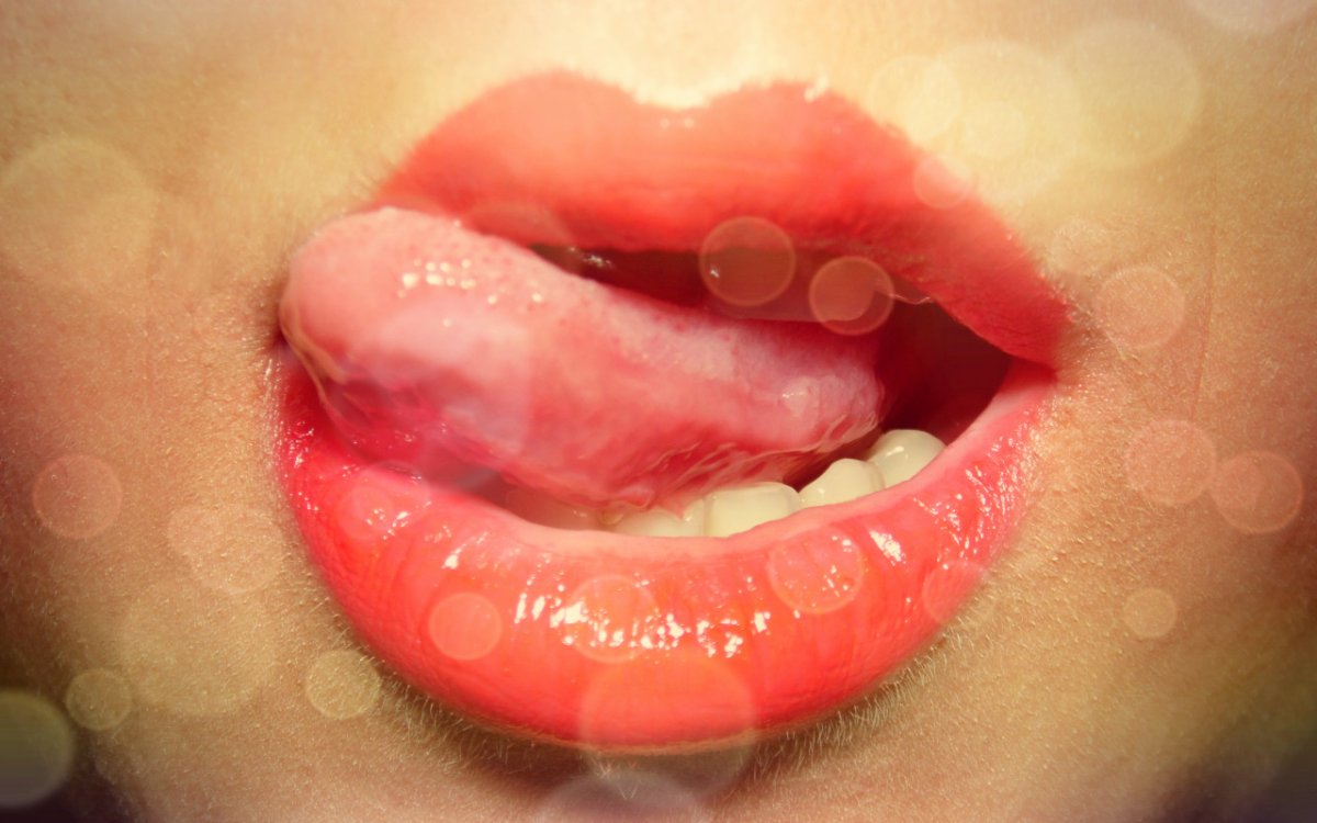 Красивая девушка облизывает губы