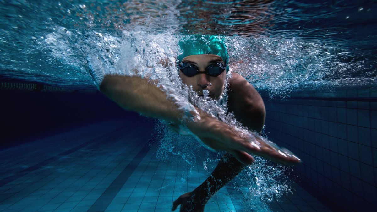 Девушка плавает в бассейне