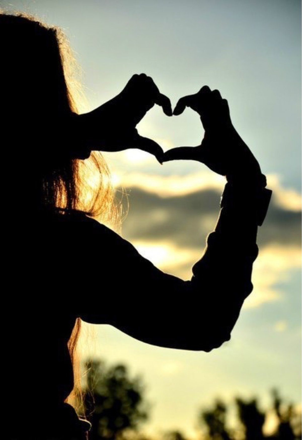 Девушка показывает сердце