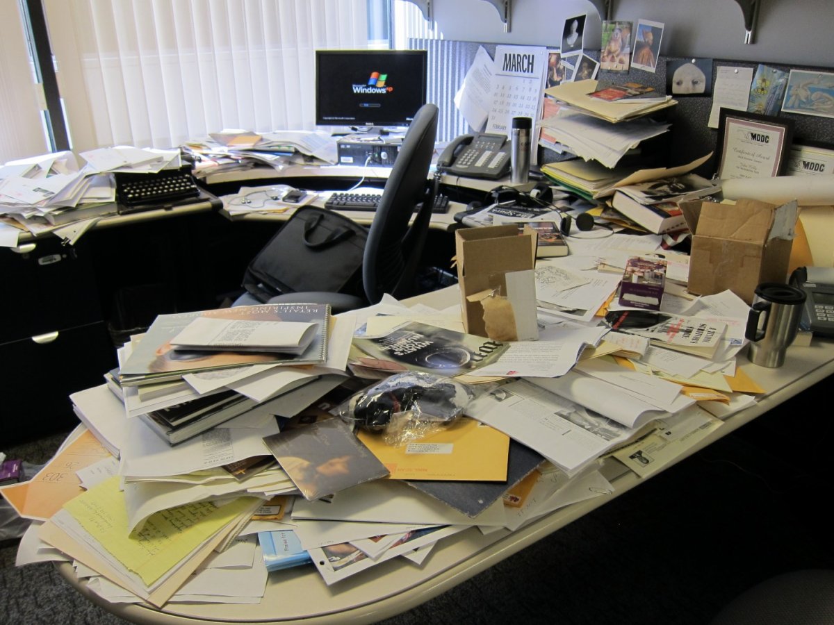 Письменный стол заваленный бумагами в офисе