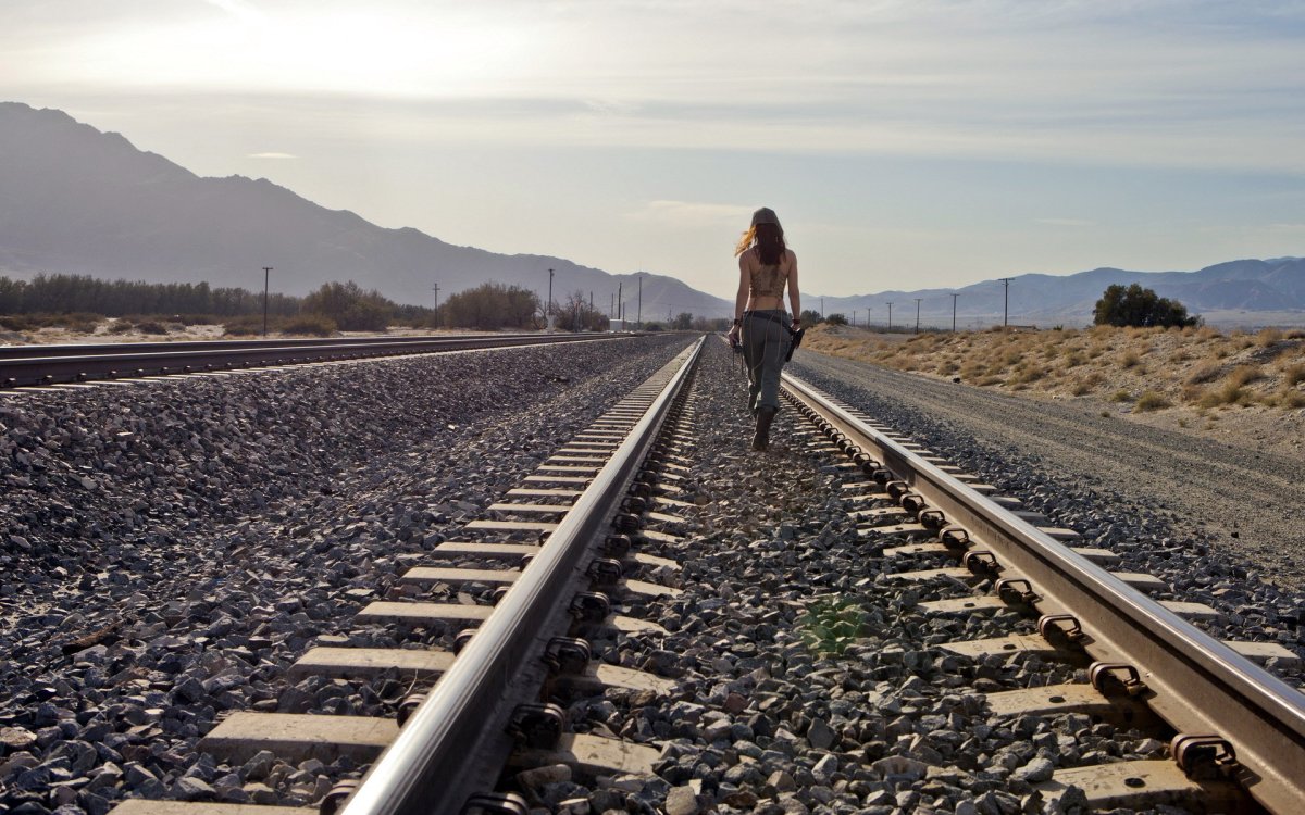 Девушка идет по рельсам