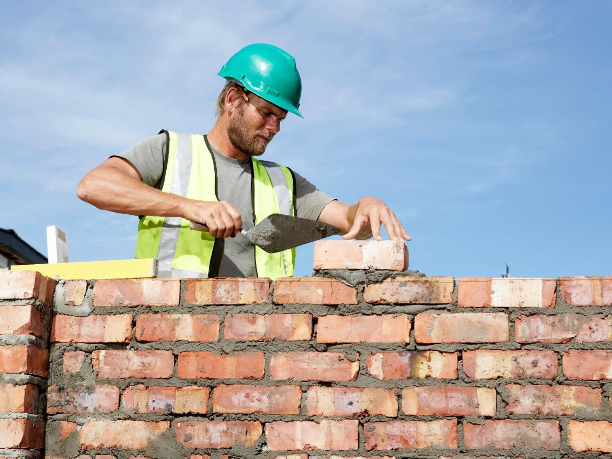 Строитель кладет кирпич