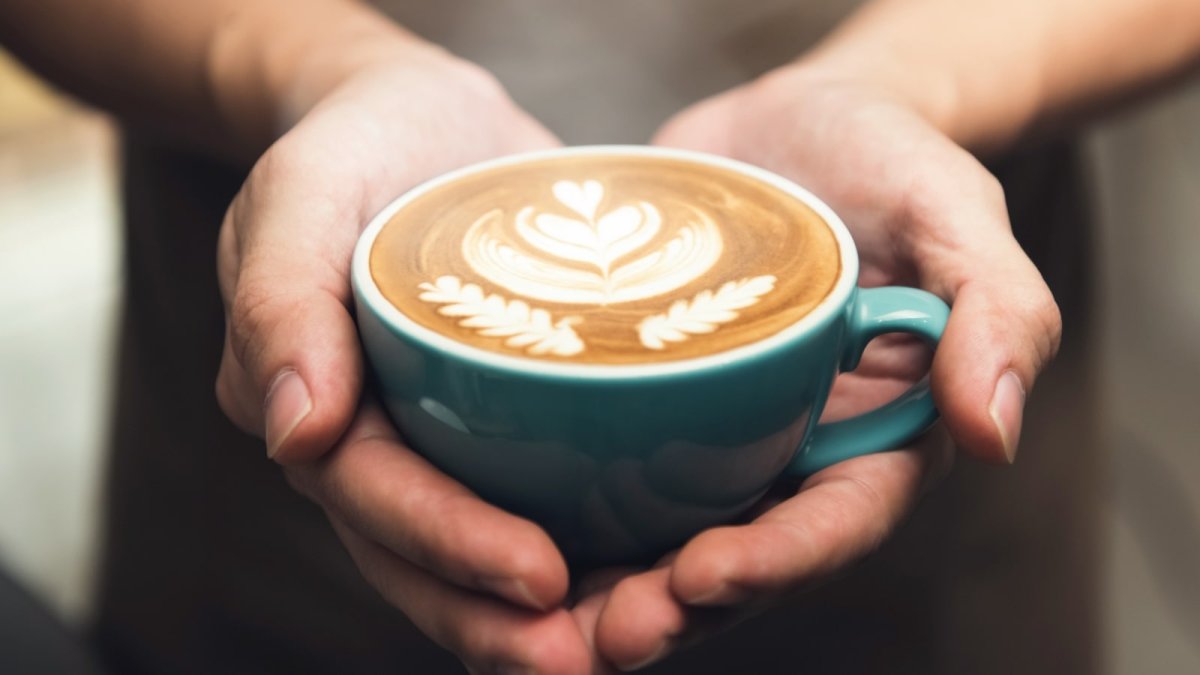 Рука с чашкой кофе протягивает