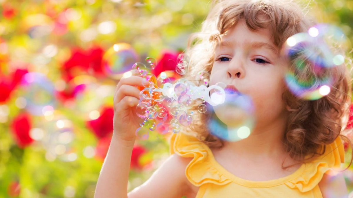 Ребенок дует мыльные пузыри