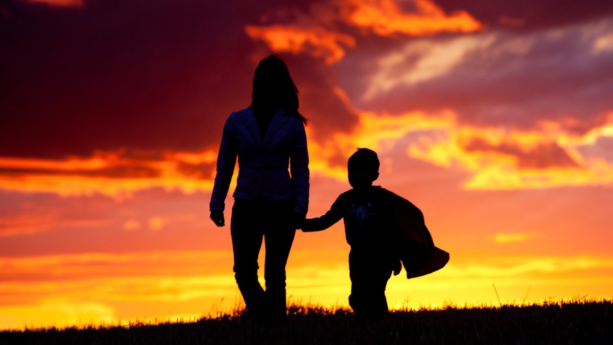 Силуэт женщины и ребенка на закате