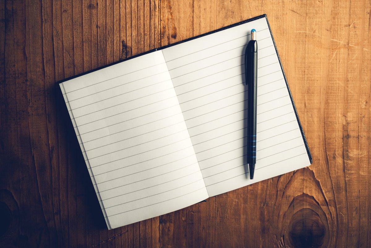 Открытый блокнот с ручкой