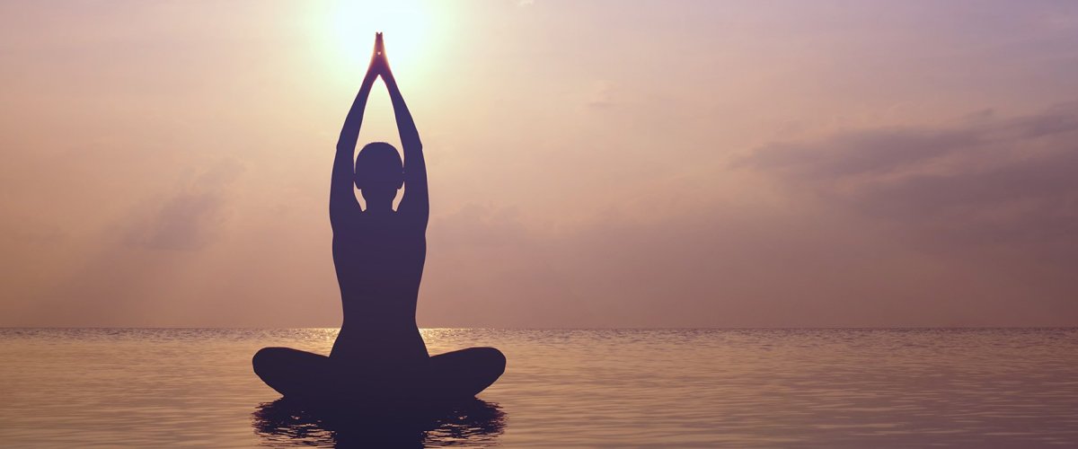 Девушка в позе лотоса на закате