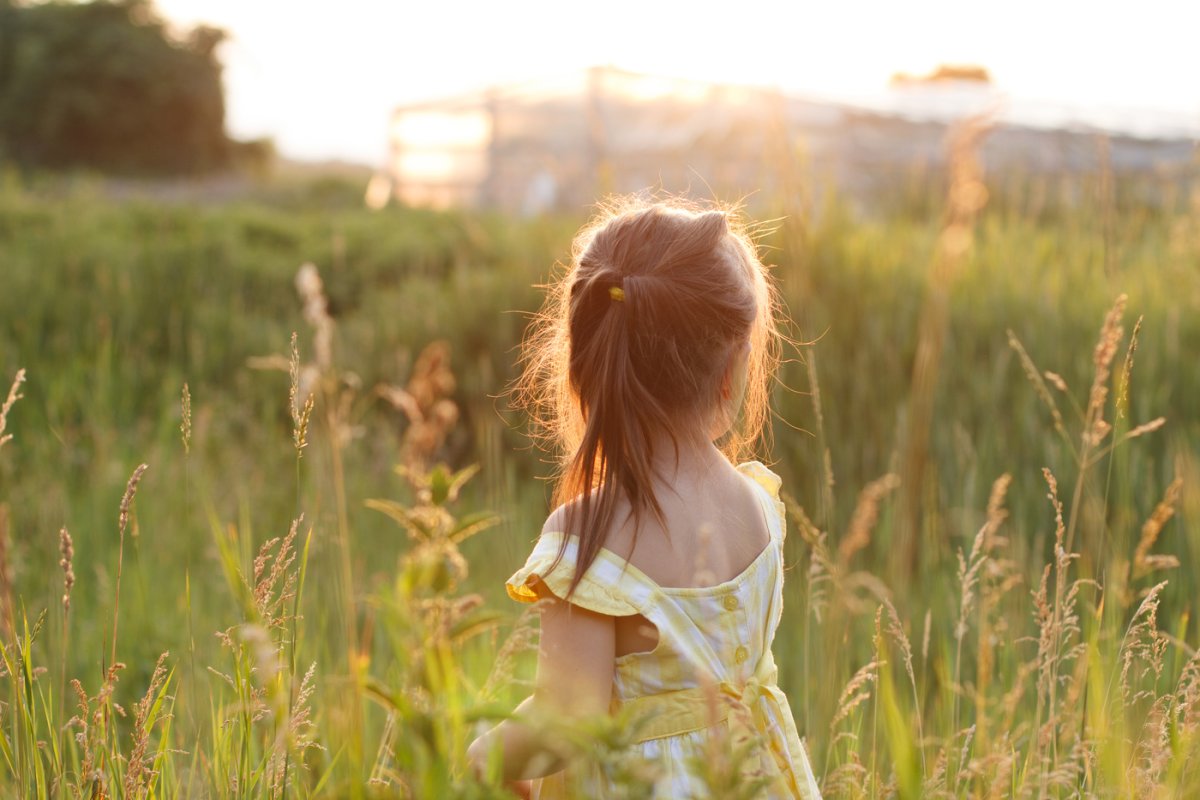 Девушка в поле со спины