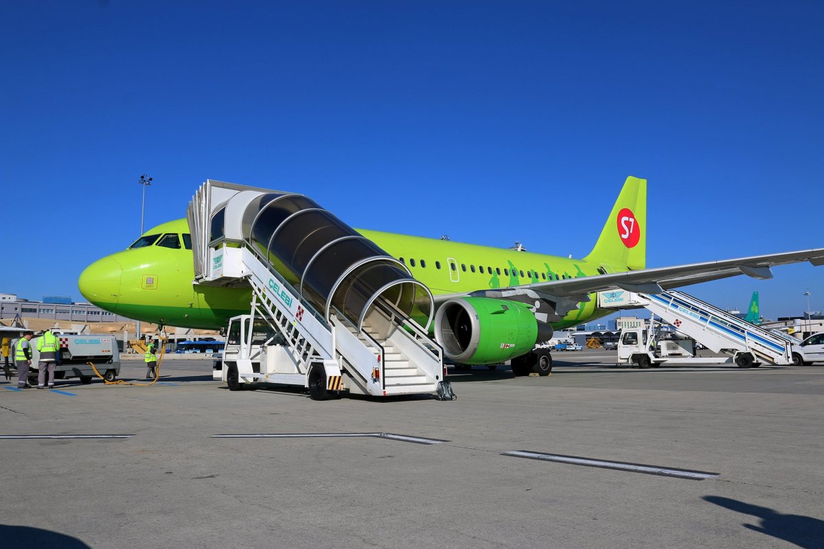 Люди спускаются по трапу самолета