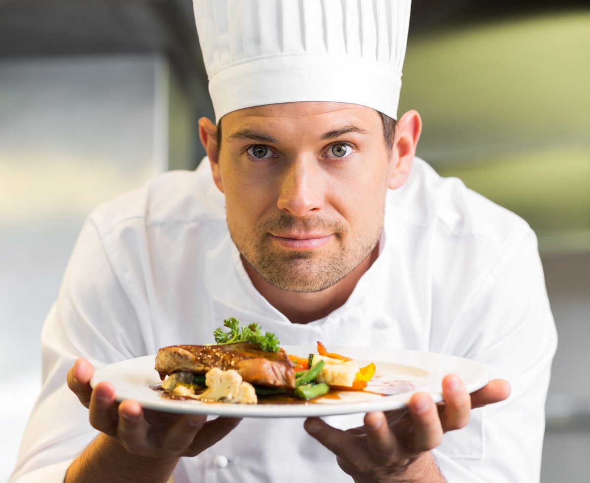 Повар с блюдом в руках