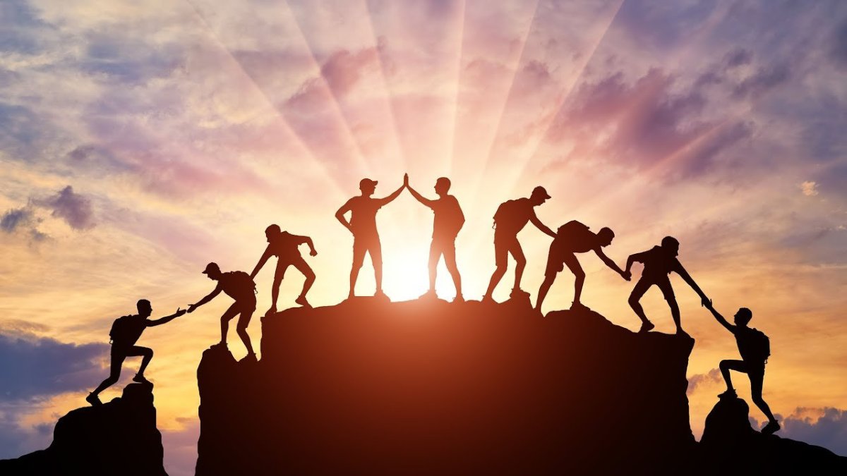 Команда на вершине горы силуэты