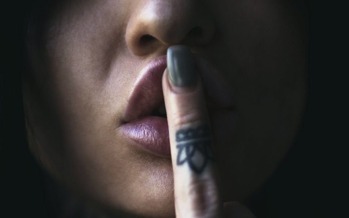 Девушка с пальцем у губ