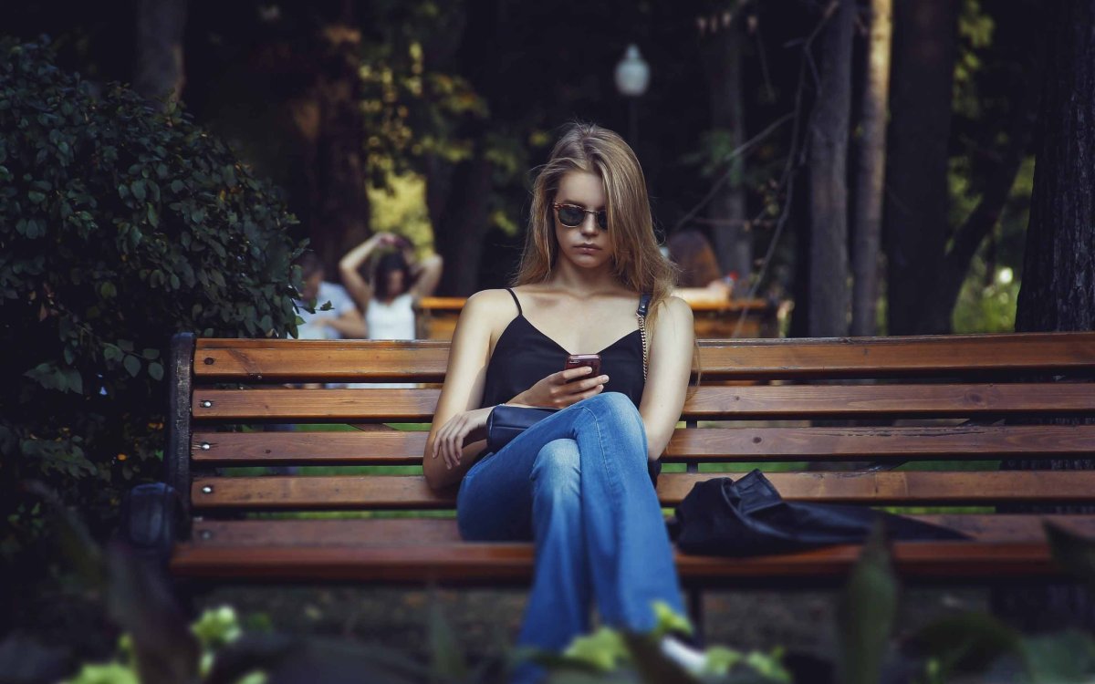 Девушка сидит на скамейке