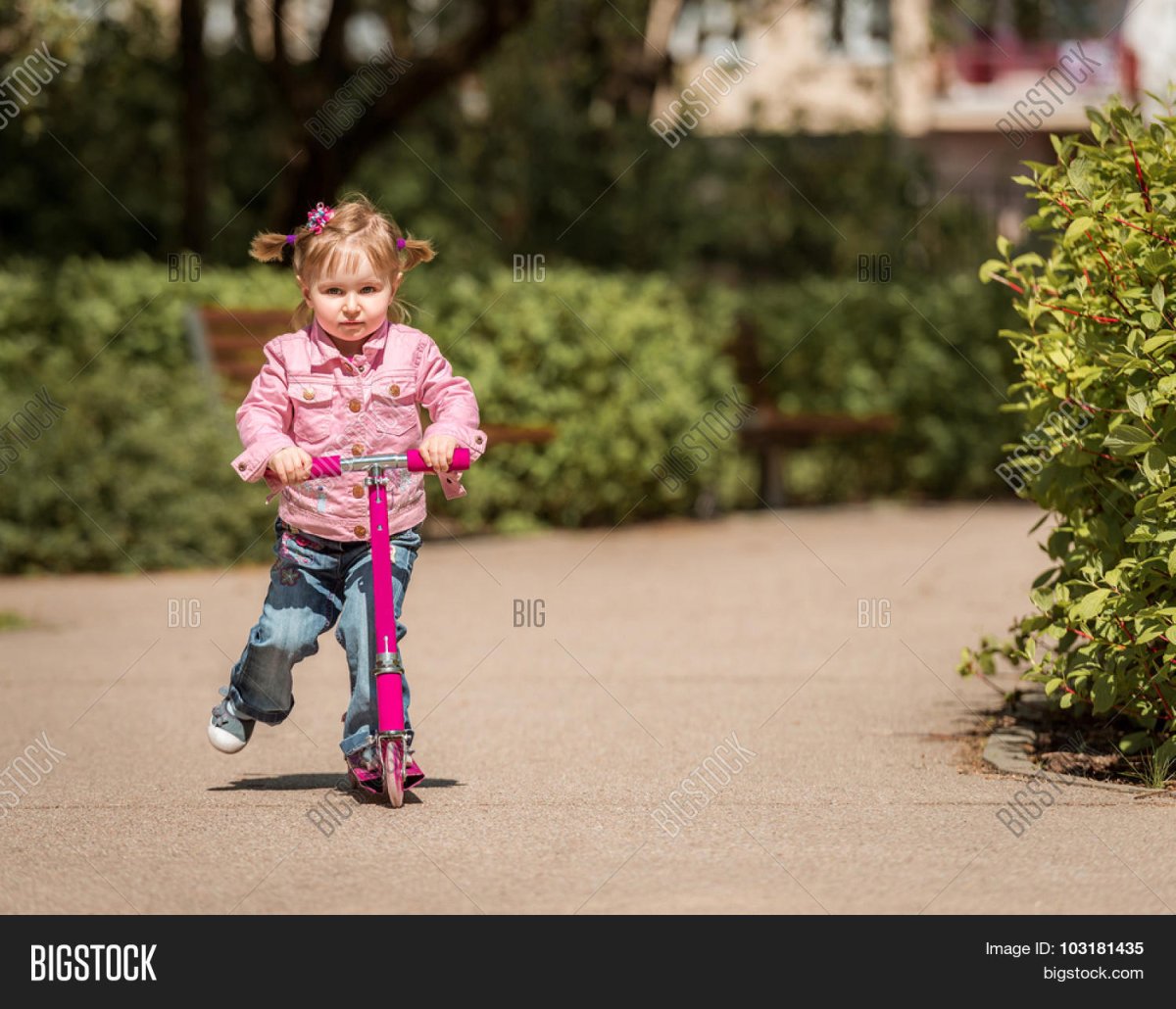 Две девочки катаются на самокате