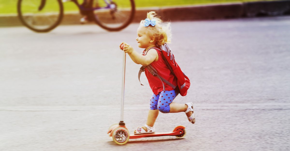 Девочка малыш катается на самокате