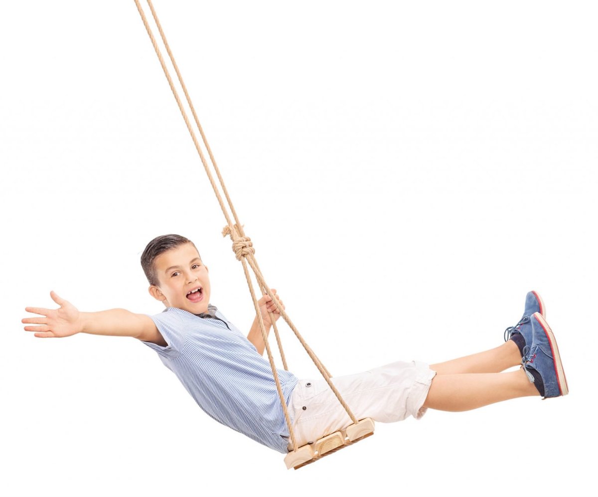 Мальчик качается на качелях