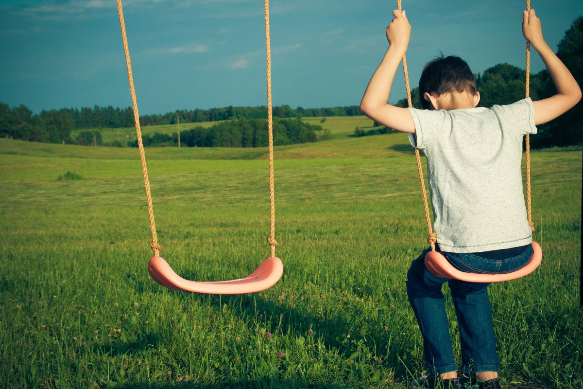 Одинокий мальчик на качелях