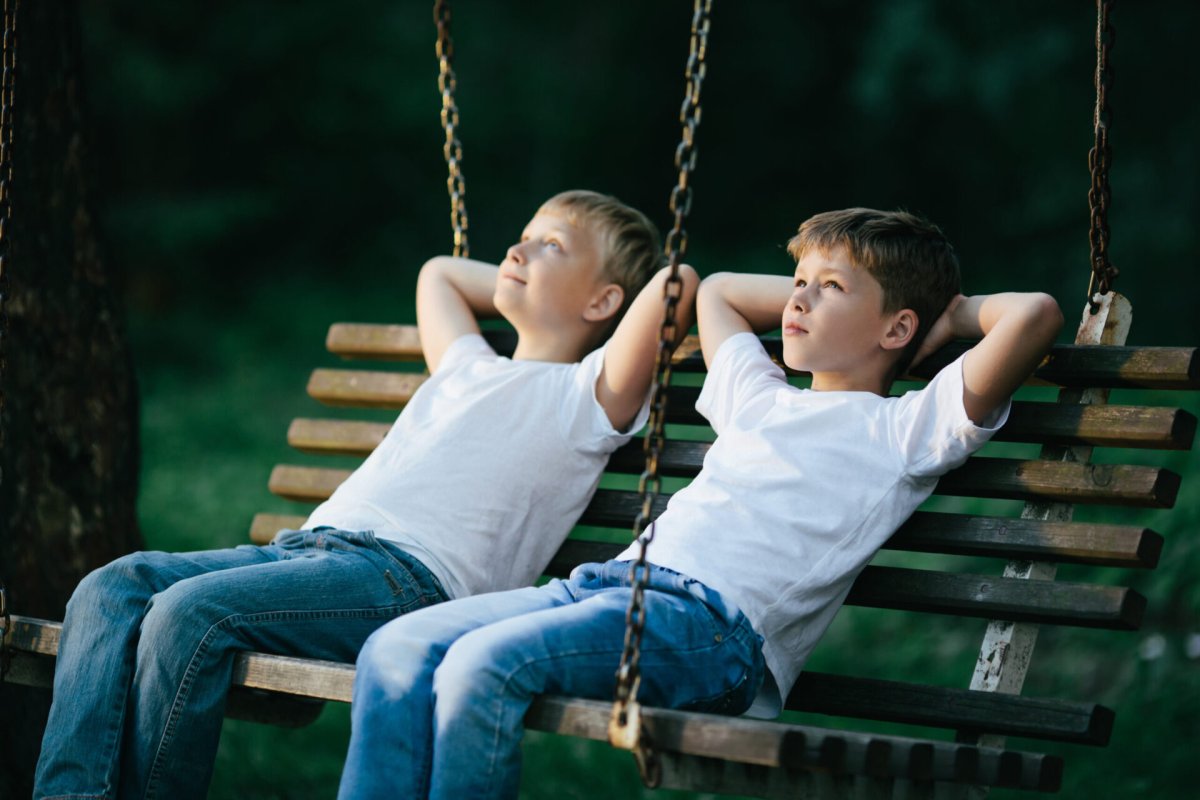 Мальчик сидит на качелях