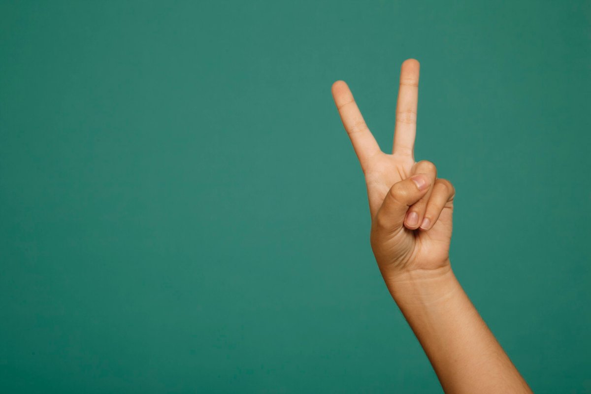 Показывает два пальца