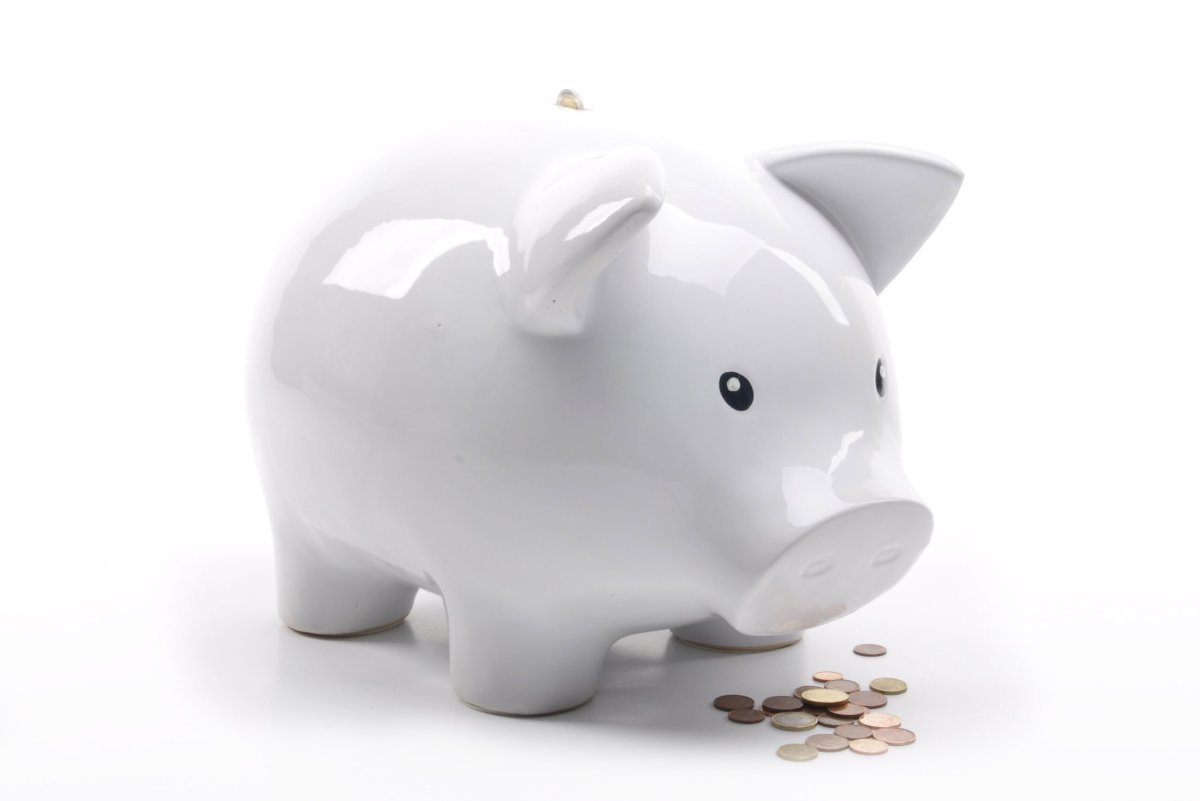 Копилка с деньгами на белом фоне