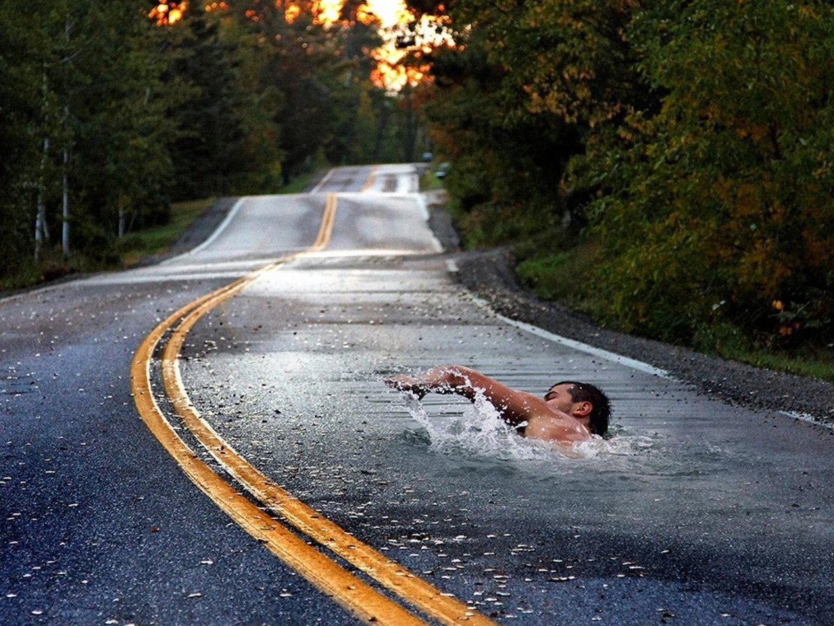 Осенним вечером случилось мне плыть. Плывет по дороге. Красивая дорога и человек. Вода на дороге.