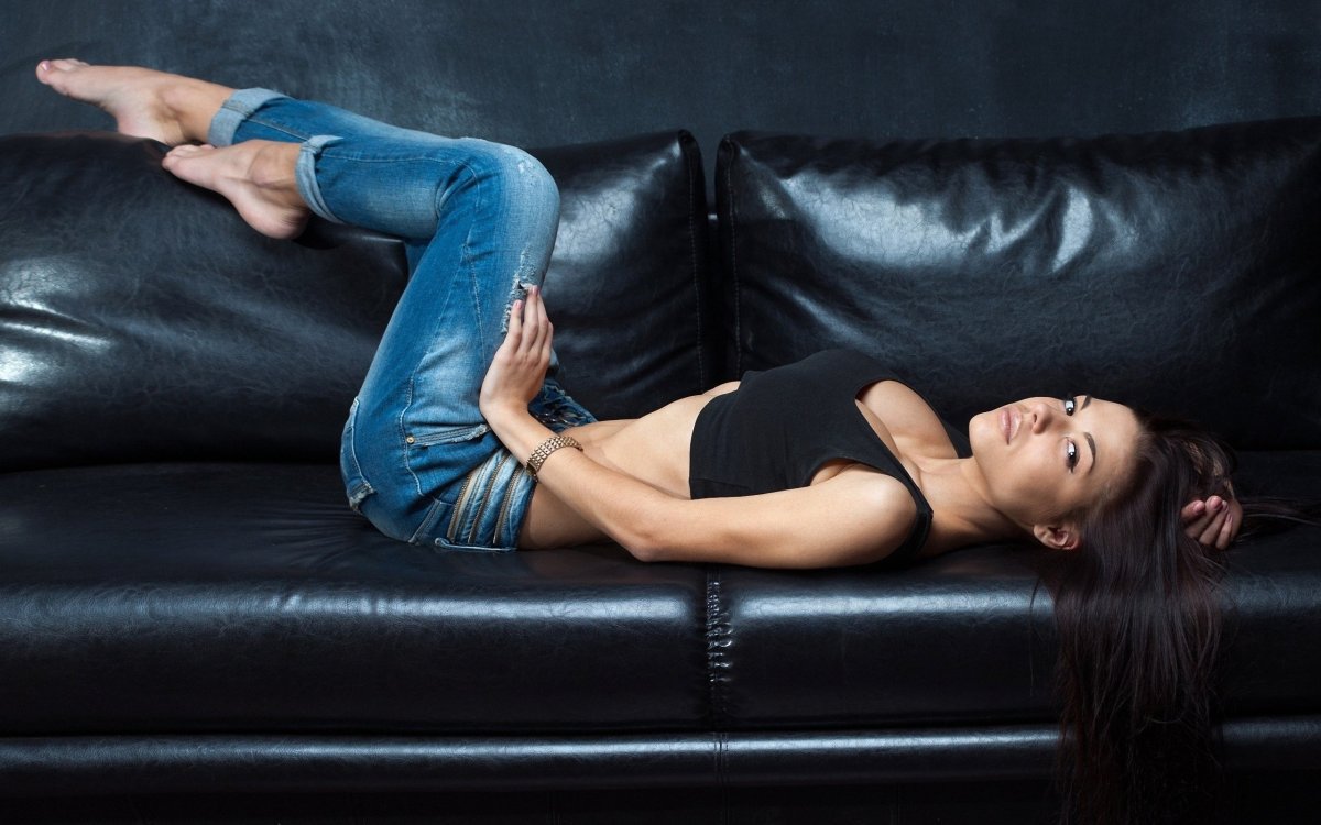 Человек сидит на диване с ноутбуком