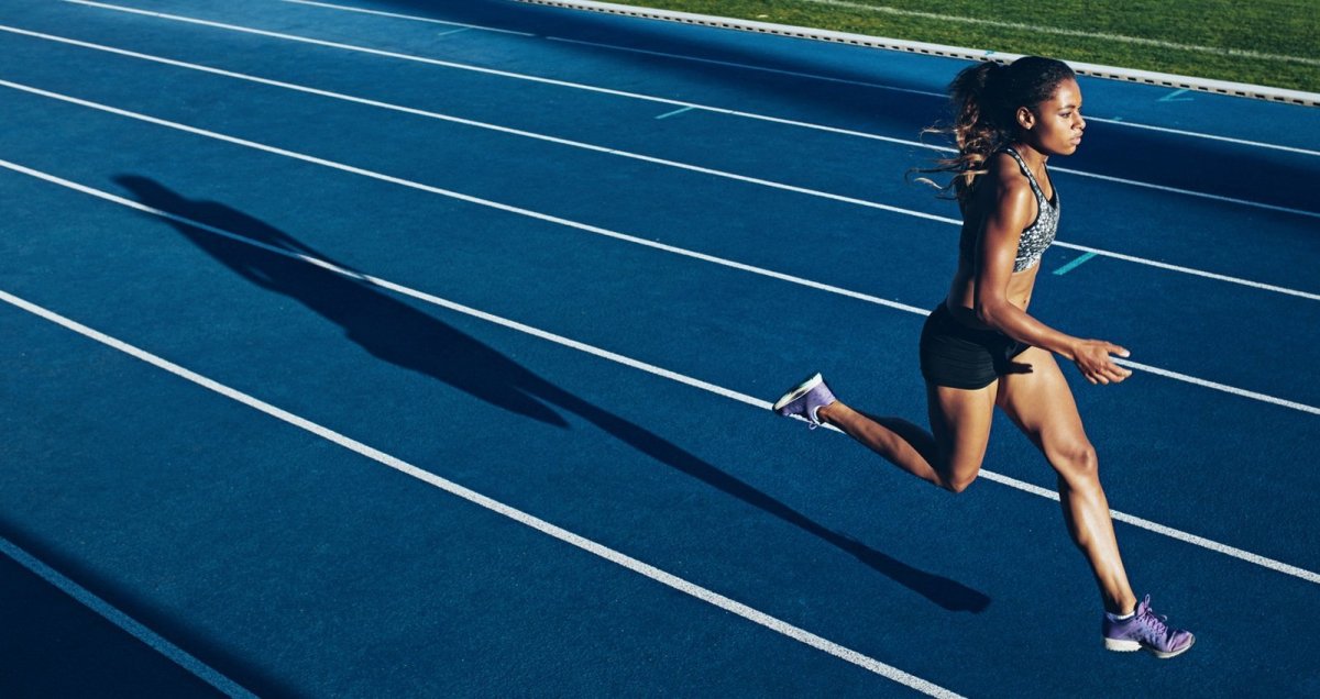 Девушка бежит по стадиону