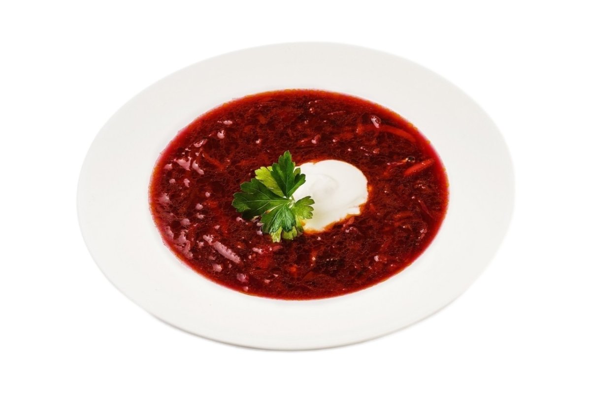 Тарелка борща на белом фоне