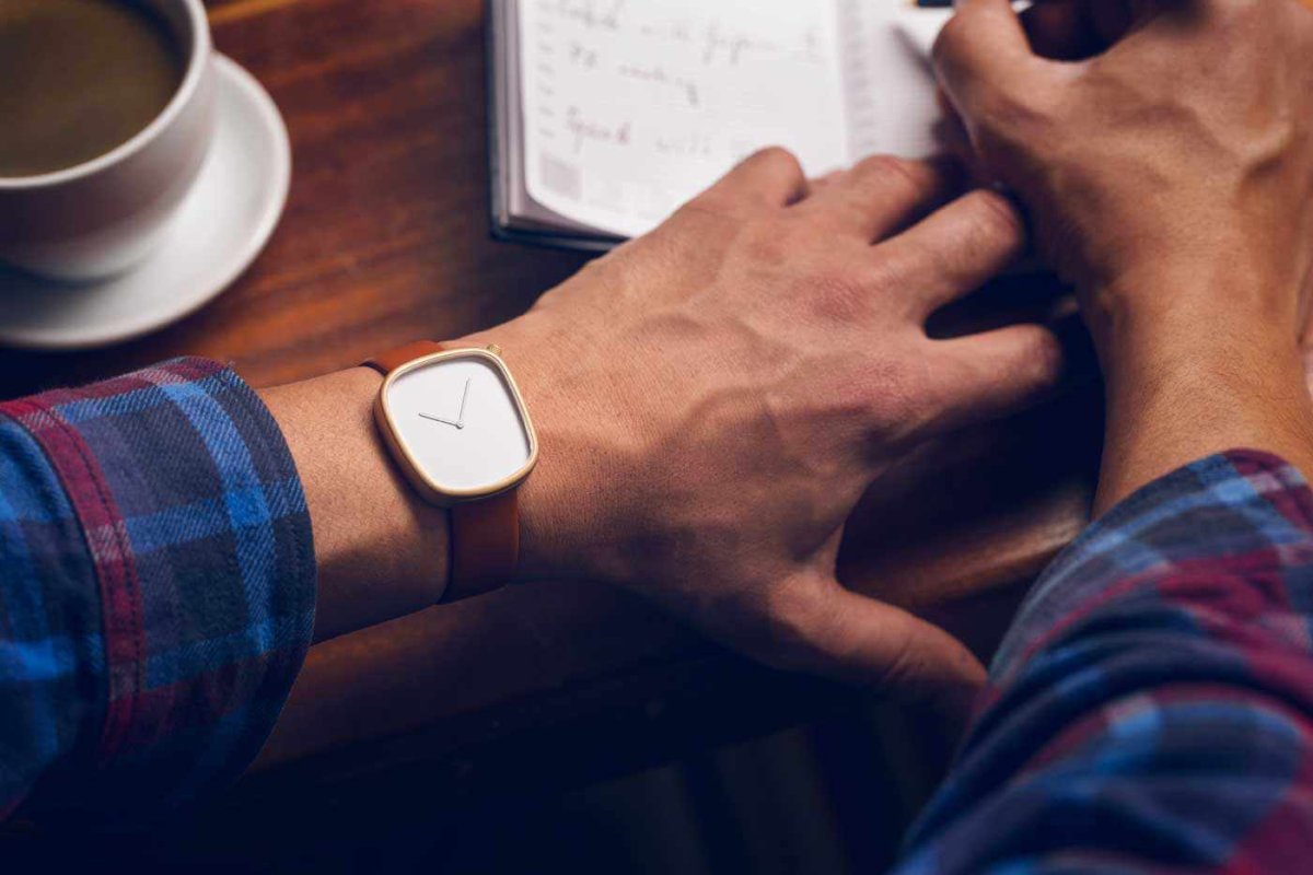 Мужская рука с часами на столе