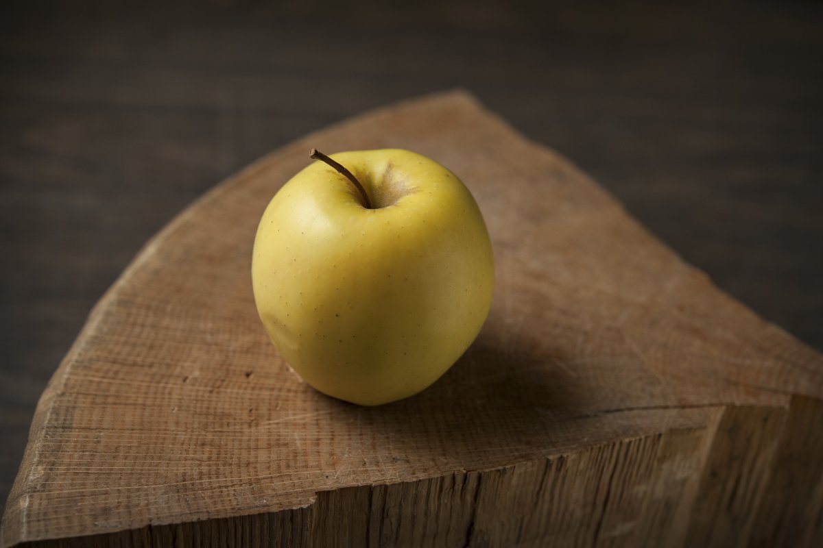 Желтое яблоко на столе