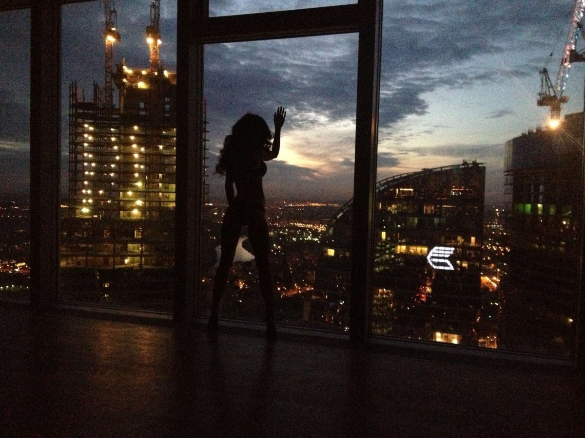 Девушка у окна с видом на город