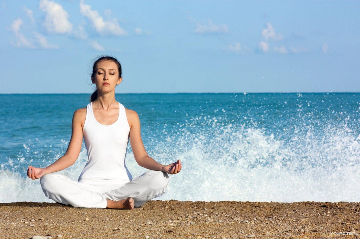 Девушка медитирует на берегу