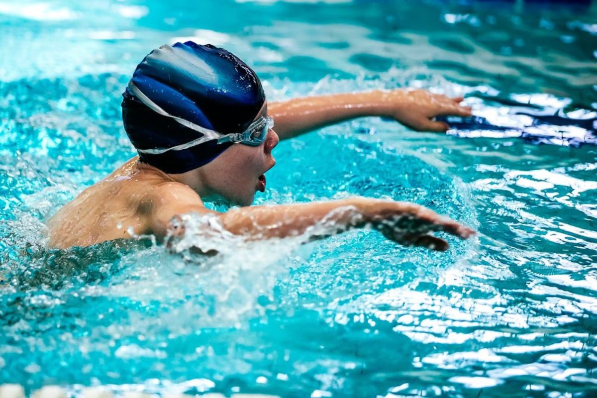 Мальчик плавает в бассейне