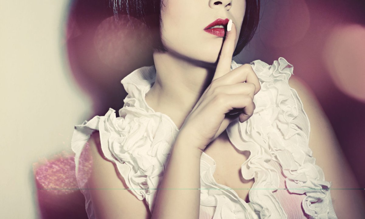 Девушка прикладывает палец к губам