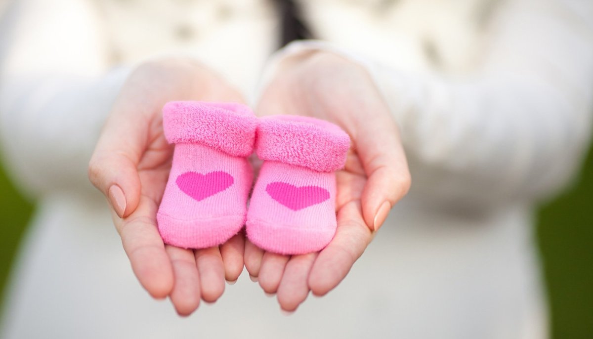 Беременная с пинетками в руках