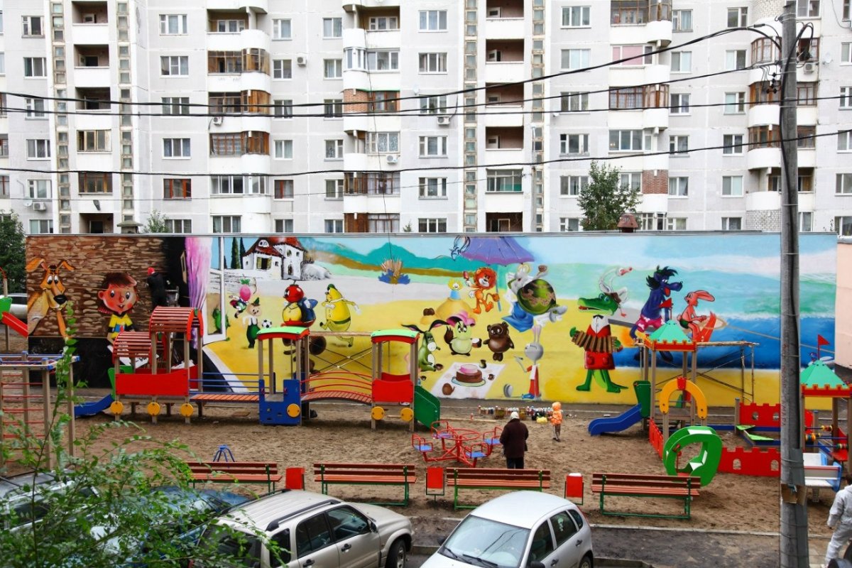 Двор многоэтажки с детской площадкой