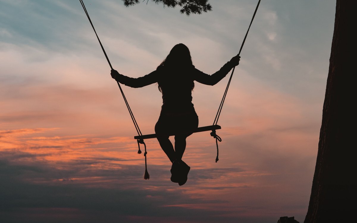 Девушка на качелях над городом