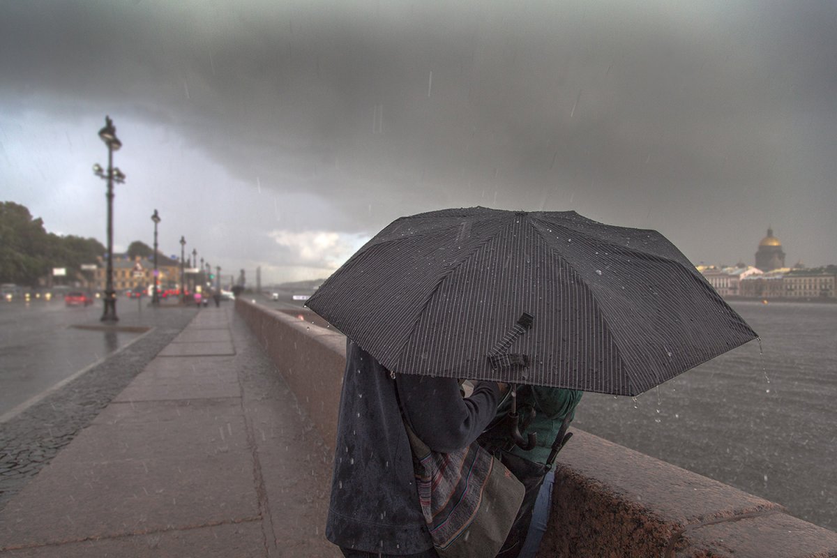 Человек с зонтом под дождем